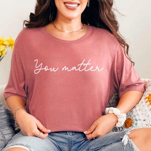 May include: A mauve colored t-shirt with the text "You matter." printed in white.