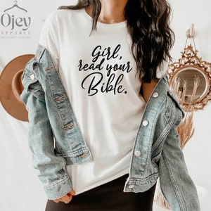 Pode incluir: Camiseta branca com texto preto que diz "Girl, read your Bible."