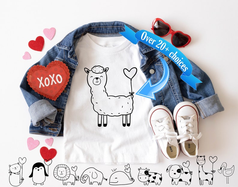 Peut inclure: T-shirt blanc avec une illustration noir et blanc d'un lama tenant un ballon en forme de c&oelig;ur. Le texte "XOXO" est sur un autocollant en forme de c&oelig;ur rouge. Le t-shirt est sur une veste en jean avec un ruban bleu qui dit "Plus de 20 choix".