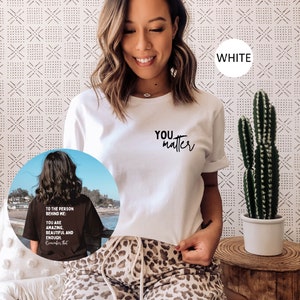May include: White t-shirt with the text "YOU matter" printed in black. The model is wearing the shirt with leopard print pants.