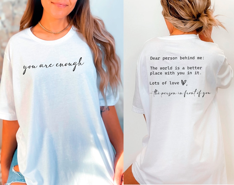 May include: White t-shirt with the text "you are enough" printed on the front and "Dear person behind me: The world is a better place with you in it. Lots of love, - the person in front of you" printed on the back.