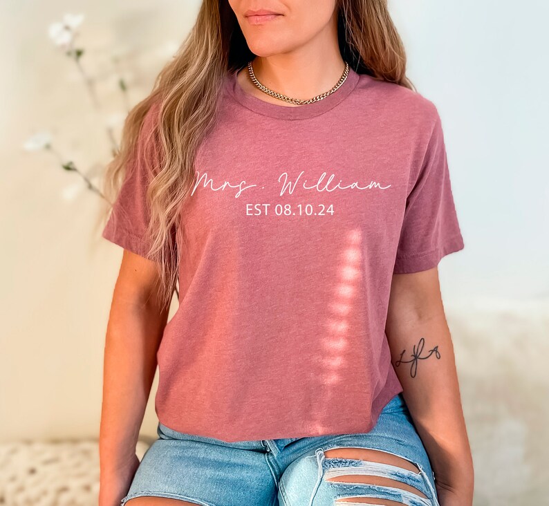 May include: A mauve cropped t-shirt with the text "Mrs. William EST 08.10.24" in white lettering.