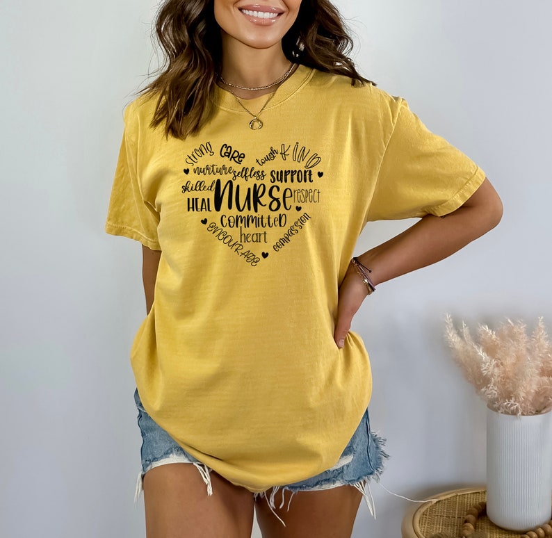 May include: A yellow t-shirt with a black graphic design that says "strong care touch of kind nurture selfless support skilled NURSE respect heal committed heart encourage compassion".