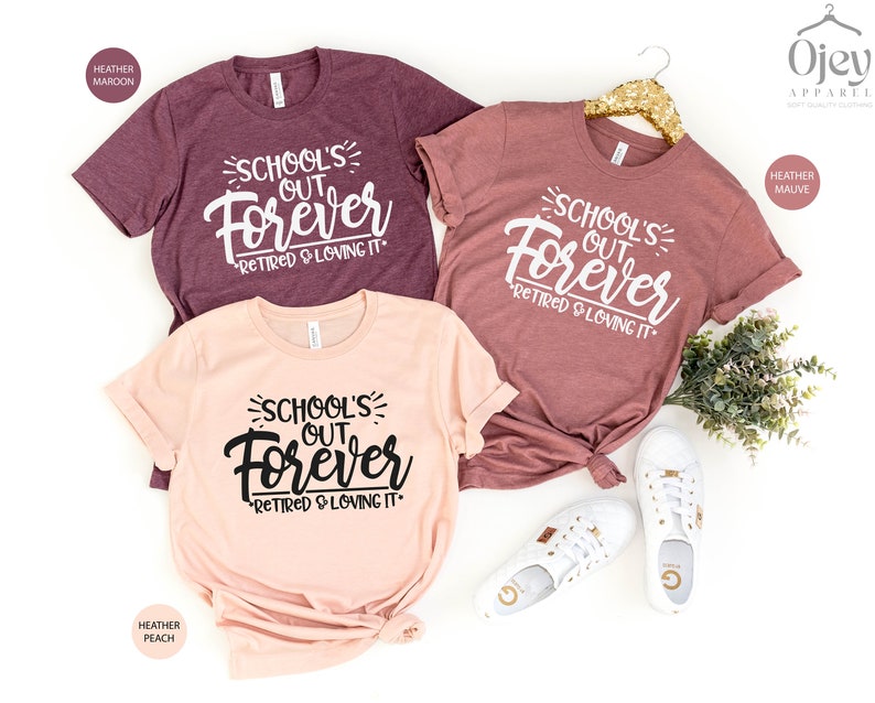 Puede incluir: Tres camisetas con el texto "School's Out Forever" y "Retired & Loving It" en texto blanco y negro. Las camisetas son de color marr&oacute;n jaspeado, melocot&oacute;n jaspeado y malva jaspeado.