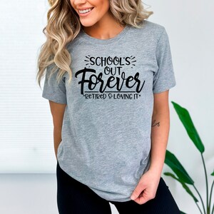 Puede incluir: Camiseta gris con texto negro que dice "School's Out Forever - Retired & Loving It."