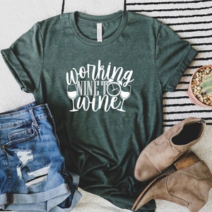 May include: A green t-shirt with the text "Working Nine to Wine" in white lettering. The text is accompanied by two wine glass icons and a clock icon.