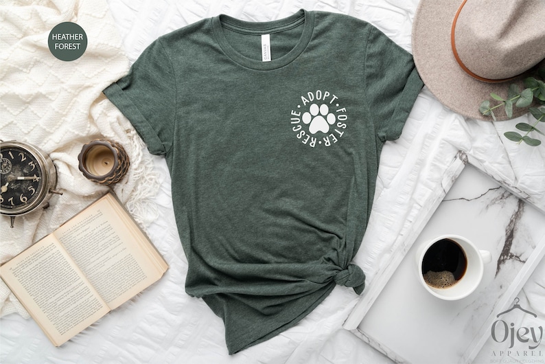 May include: A green t-shirt with a white paw print and the text "Adopt. Foster. Rescue." in a circle around the paw print.