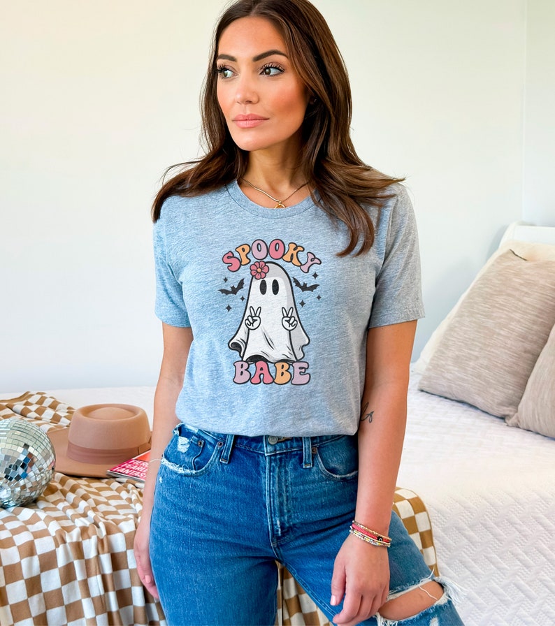 May include: A gray t-shirt with a graphic of a ghost with a flower in its hair and the text "Spooky Babe" in colorful letters.