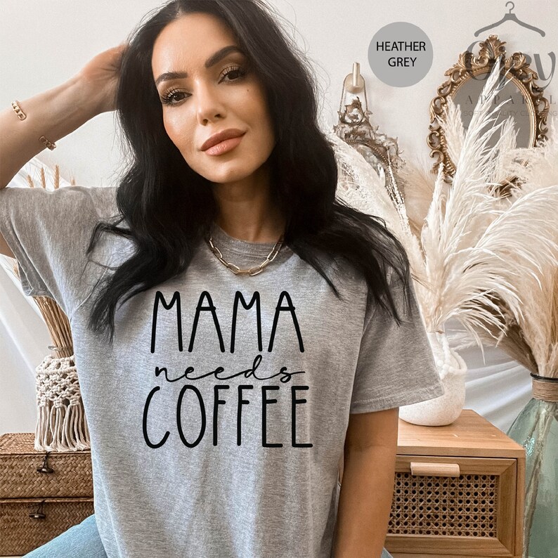 May include: A heather grey t-shirt with the text "MAMA needs COFFEE" printed in black.