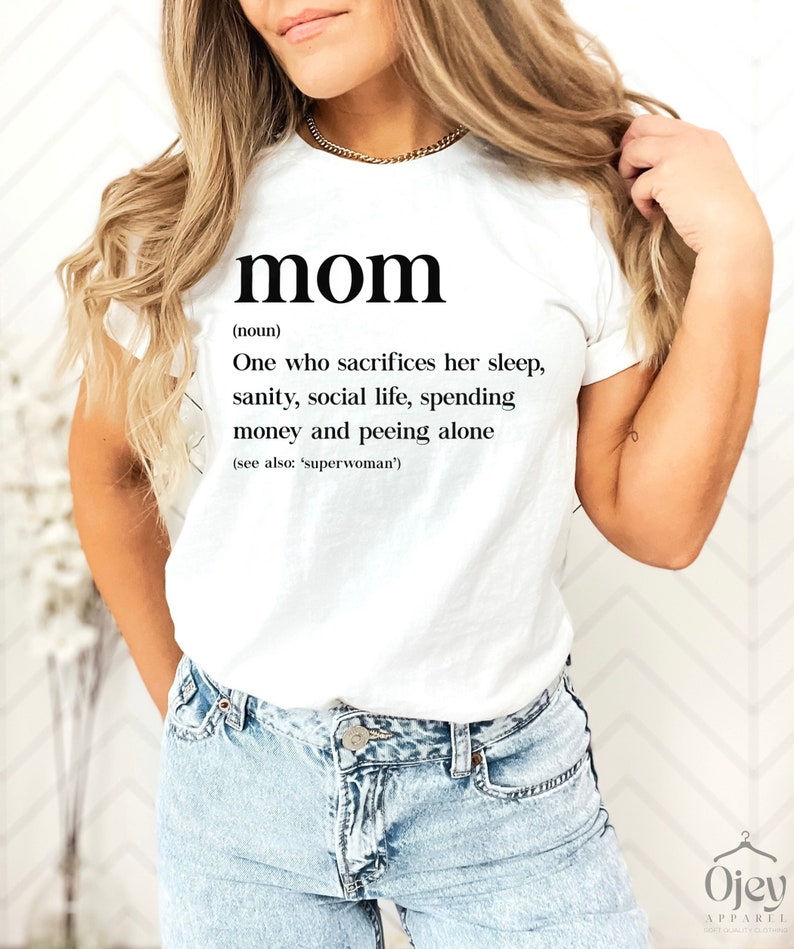 Może przedstawiać: Biała koszulka z czarnym tekstem, kt&oacute;ry brzmi "mom (noun) One who sacrifices her sleep, sanity, social life, spending money and peeing alone (see also: 'superwoman')"