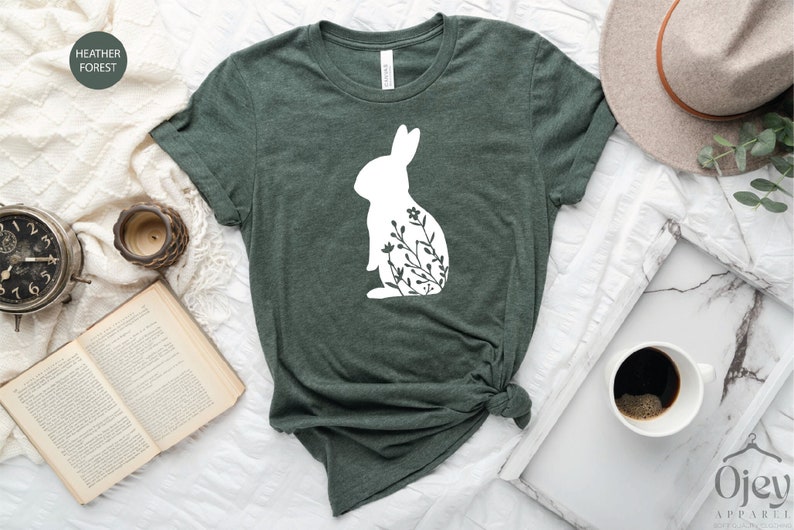 May include: A green t-shirt with a white silhouette of a rabbit with flowers inside the silhouette.