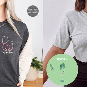 May include: Two women's t-shirts with the text "Nurse Strong" and different graphic designs. The first shirt is heather dark grey with a pink stethoscope and heart design. The second shirt is heather athletic grey with a green hand holding a stethoscope.