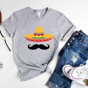 May include: A heather grey t-shirt with a black mustache and a yellow, red, green, and orange sombrero.