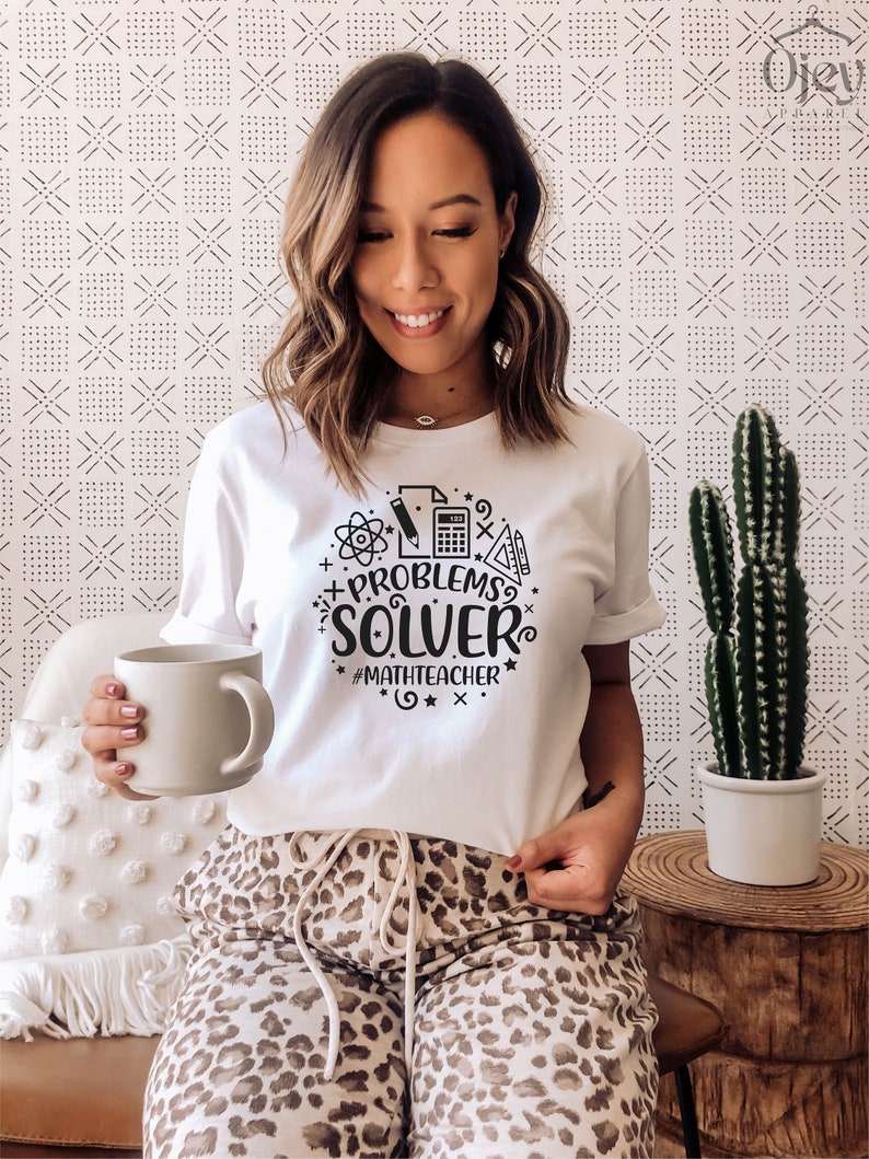 May include: A white t-shirt with a black graphic design that says "Problem Solver" with math symbols and the hashtag "#mathteacher".