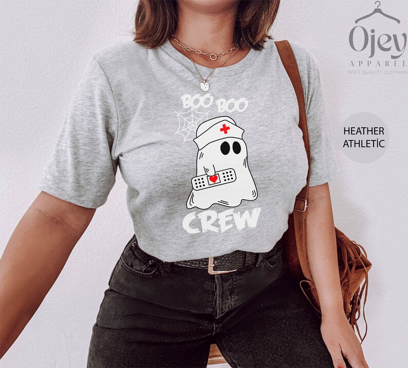 May include: A grey t-shirt with the text "Boo Boo Crew" and a cartoon ghost wearing a nurse's hat and holding a bandage with a heart on it.