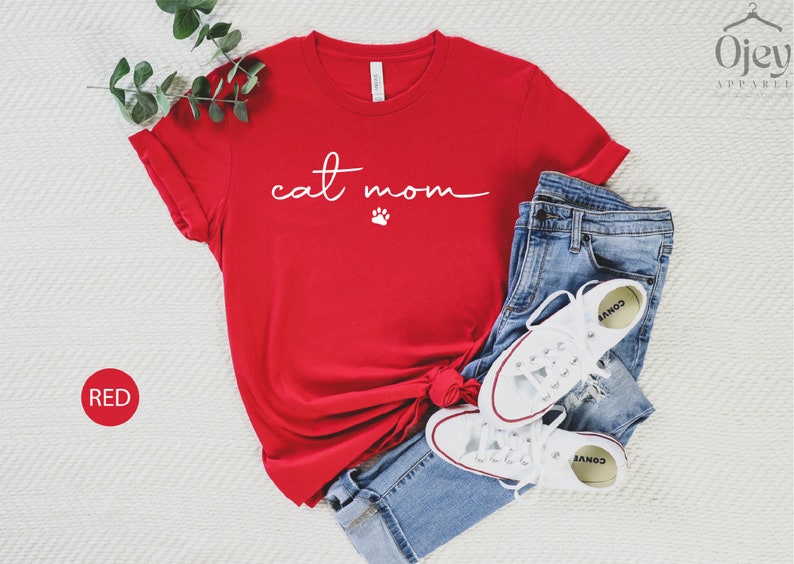 May include: Red t-shirt with the text "cat mom" in white with a paw print below the text.