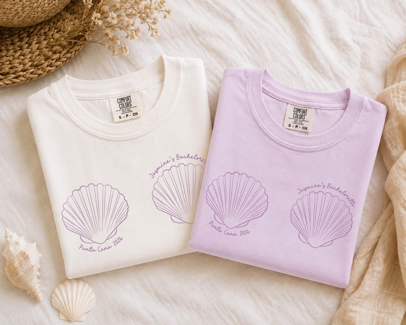 May include: Two crew neck t-shirts, one white and one light purple, each featuring two purple line-art seashell illustrations. The text "Jasmine's Bachelorette" and "Punta Cana 2026" is printed in purple near the shells on both garments.