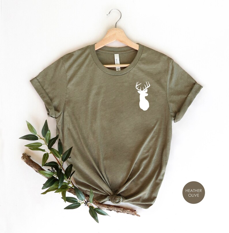May include: A heather olive t-shirt with a white silhouette of a deer head with antlers on the front.