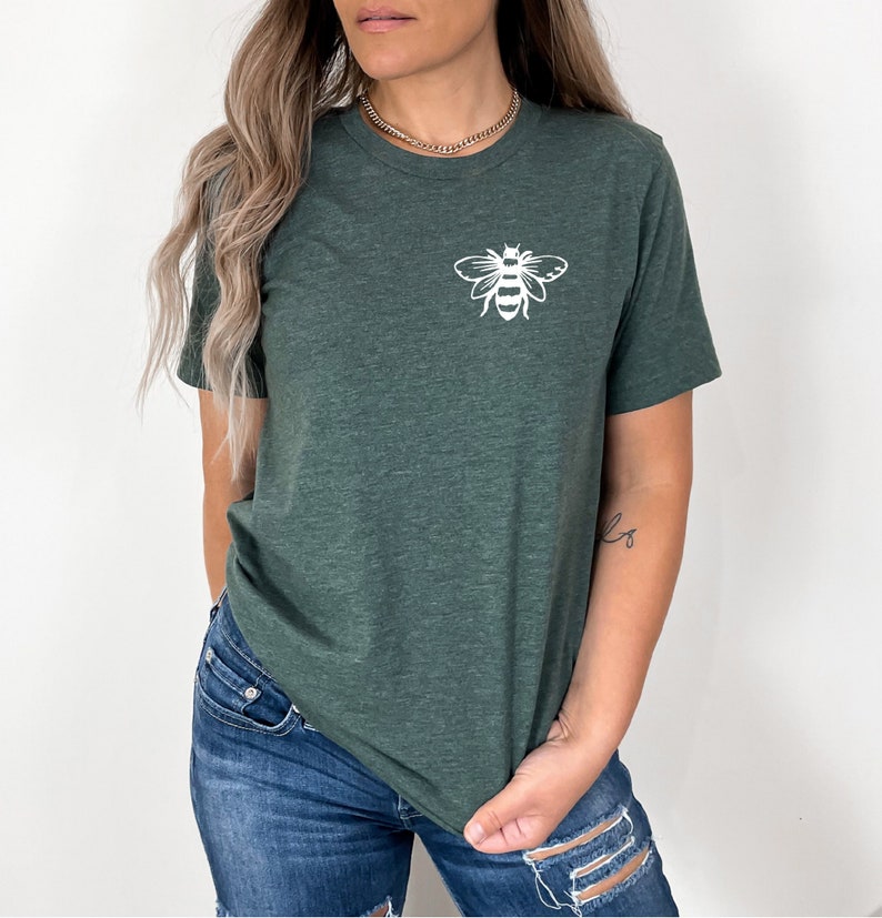 May include: A dark green t-shirt with a white bee graphic on the front. The shirt is made of a soft, comfortable material and has a relaxed fit.