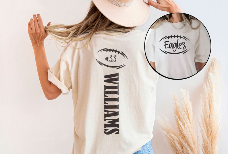 May include: White t-shirt with a black football graphic and the text "#33 WILLIAMS" on the back. The front of the shirt has a black football graphic with the text "Eagles".