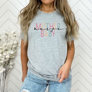 Puede incluir: Camiseta gris con el texto "MOTHER" en naranja, "NURSE" en verde y "BABY" en rosa.