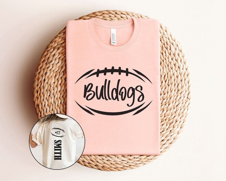 May include: A pink t-shirt featuring a black football graphic and the text "Bulldogs". A white t-shirt with the text "Smith #25" is also shown.