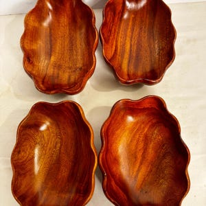 Puede incluir: Una taza de cerámica blanca con un asa negra y el texto "But First, Coffee" en un estilo manuscrito. La taza está sobre una superficie blanca. La taza mide aproximadamente 10 cm de alto.