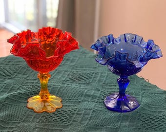 A pair of vintage Fenton Amberina glass compote dishes with ruffled rims.