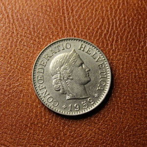 May include: A silver Swiss coin with the inscription "CONFOEDERATIO HELVETICA" and the year "1959" on the front.