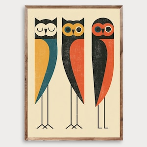May include: A framed wall art print featuring three stylised owls standing in a row against a cream background. The owls are depicted with geometric shapes, long thin legs, and a colour palette of black, blue, yellow, and orange with textured details.