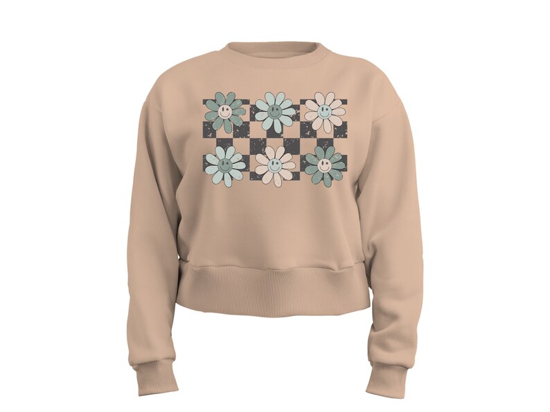 May include: A beige cropped sweatshirt with a checkered pattern and six pastel green, blue, and pink flowers with smiley faces.