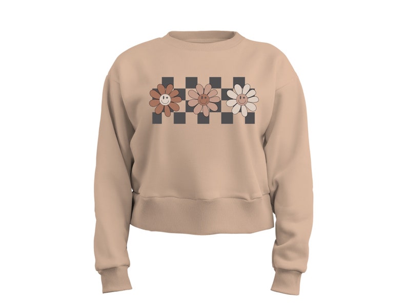 May include: A beige cropped sweatshirt with a checkered pattern and three smiling flower designs in shades of brown, pink, and white.