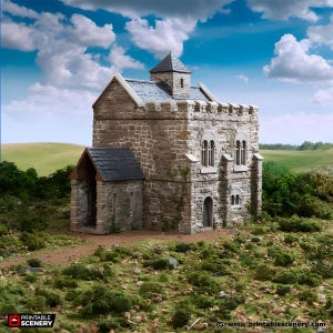 May include: A miniature stone castle with a small tower and arched windows. The model has a gray slate roof and is set on a grassy landscape under a blue sky with clouds. The text "Printable Scenery" is visible.