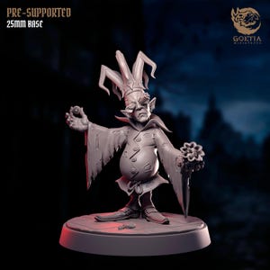May include: A gray miniature figure of a jester with a tall hat and tattered sleeves, holding a small ball and a flower-like object. The figure stands on a 25mm base, with the text "PRE-SUPPORTED 25mm BASE" visible.