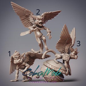 May include: Three beige fantasy figurines with intricate details. One figure stands with outstretched wings, holding a blade. Another is crouching, and the third is perched on a decorative object. The figures have monkey-like faces and wear jewellery.
