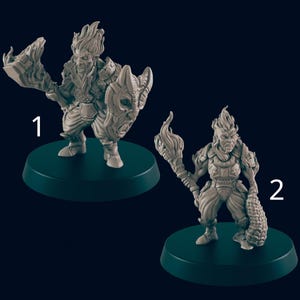 May include: Two grey miniature fantasy figures on dark green bases. One figure holds a shield with a skull design and a large weapon. The other figure holds a torch and a club-like weapon. Both figures have detailed armour and fiery hair.