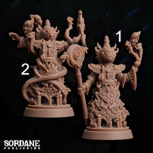 May include: Two tan-coloured fantasy figurines. One holds a staff with a spiral design, the other has a snake wrapped around it. Both figures are adorned with ornate armour and headwear, and stand on bases with small candle details.