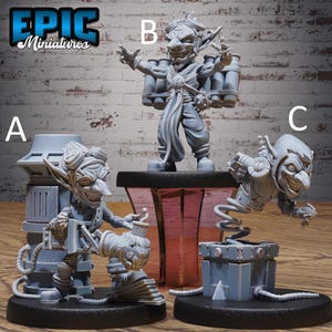 以下が含まれることがあります： 3つの灰色のミニチュアゴブリンフィギュア。1つのフィギュアは爆弾のバックパックを持って立っており、もう1つはデバイスを持ってひざまずいており、3つ目は箱から飛び出しています。「EPIC Miniatures」というテキストが左上にあります。