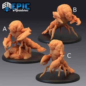 May include: Three miniature figurines of a crustacean-like creature in a light orange color. Each figure has a detailed exoskeleton, claws, and multiple legs. The figures are on black circular bases, with the "EM EPIC Miniatures" logo in the top left corner.
