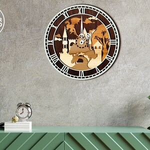 May include: A wooden clock with a white face and Roman numerals. The clock features a laser-cut design of a castle and trees. The clock is hanging on a gray wall.