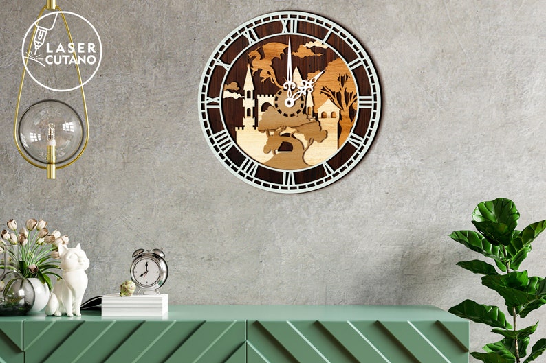 May include: A wooden clock with a white face and Roman numerals. The clock features a laser-cut design of a castle and trees. The clock is hanging on a gray wall.