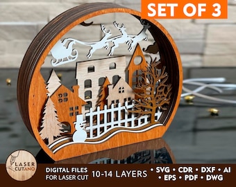 Può includere: Set di tre ornamenti natalizi in legno tagliati al laser che rappresentano una scena di villaggio invernale con la slitta di Babbo Natale, un pupazzo di neve e alberi. Gli ornamenti sono progettati per essere sovrapposti e hanno da 10 a 14 strati. I file digitali per il taglio laser sono inclusi nei formati SVG, CDR, DXF, AI, EPS, PDF e DWG.