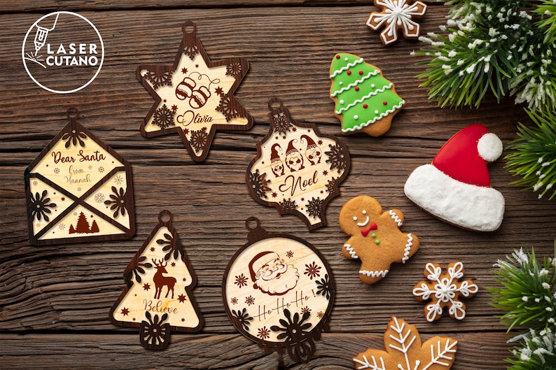 Puede incluir: Surtido de adornos navide&ntilde;os de madera con varios dise&ntilde;os, incluyendo una estrella, un &aacute;rbol, una carta a Santa Claus y una cabeza de Santa Claus. Los adornos est&aacute;n decorados con copos de nieve, renos y otros detalles festivos.