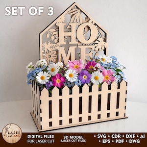 Könnte beinhalten: Eine Blumenkasten aus Holz mit Laserzuschnitt und einem Zaunmuster, gefüllt mit bunten Blumen. Das Wort "HOME" ist aus dem oberen Teil ausgeschnitten. Der Text "SET OF 3" steht oben. Die Box ist für den Laserschnitt konzipiert.