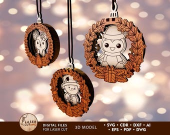 May include: Three wooden Christmas ornaments with a wreath design. Each ornament features a different animal: a deer, a penguin, and a snowman. The ornaments are laser cut and ready to be painted or decorated.