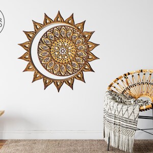 May include: A wooden sun and moon mandala wall decor with intricate details. The mandala is made of layered wood and has a brown and gold color scheme.