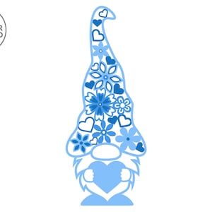 Pu&ograve; includere: Un gnomo blu con un cuore tra le mani. Il cappello del gnomo &egrave; decorato con fiori e cuori blu.