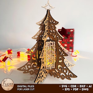 Può includere: Un albero di Natale in legno tagliato al laser con un'intricata lavorazione a volute e una stella in cima. L'albero ha una luce incorporata ed è circondato da piccole luci decorative. Il testo "DIGITAL FILES FOR LASER CUT" è visibile.