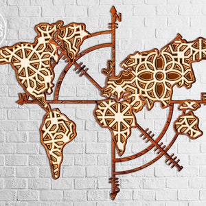 May include: A wooden world map with a compass design. The map is cut out in a geometric pattern and has a light brown color. The compass has a black needle and a white background.