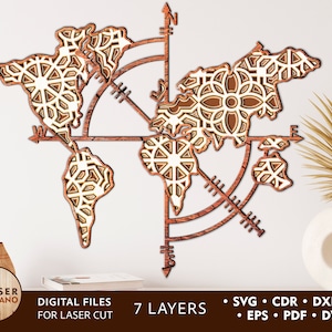 May include: A laser cut wooden world map with a compass design. The map is made of seven layers and has a detailed intricate pattern. The map is brown and white and has a compass rose in the center.